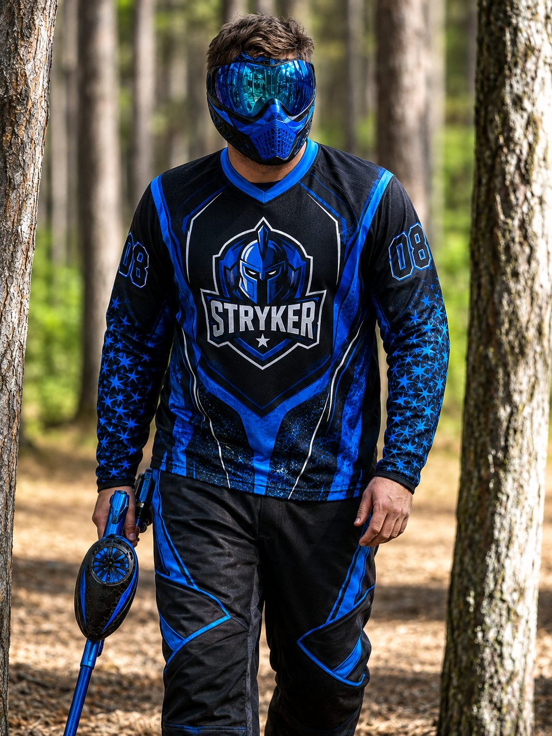Paintballspieler im Wald mit blauem Dye Paintballmarkierer
